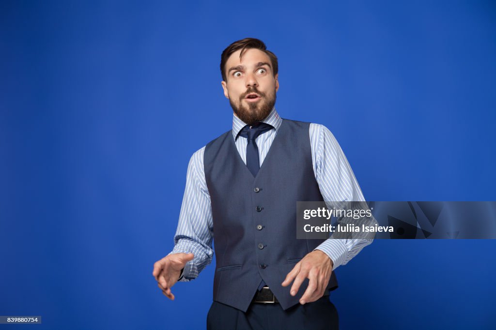 Man looking terrified on blue background