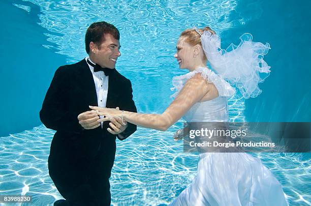 bride gets a ring from her groom underwater - bride underwater stock pictures, royalty-free photos & images