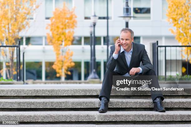 businessman talking on phone outside. - hand op knie stockfoto's en -beelden