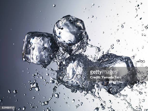 ice cubes with splash water - ice cube stock pictures, royalty-free photos & images