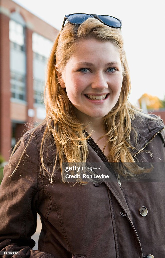 Teen girl outside high school, smiling,portrait