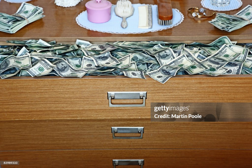 An abundance of 100 dollar bills in old dresser