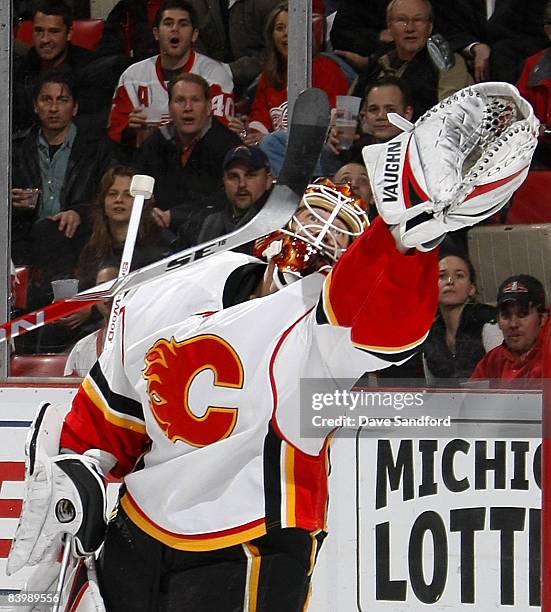 Curtis McElhinney of the Calgary Flames stretches for the puck as he makes a glove save against the Detroit Red Wings during their NHL game at Joe...