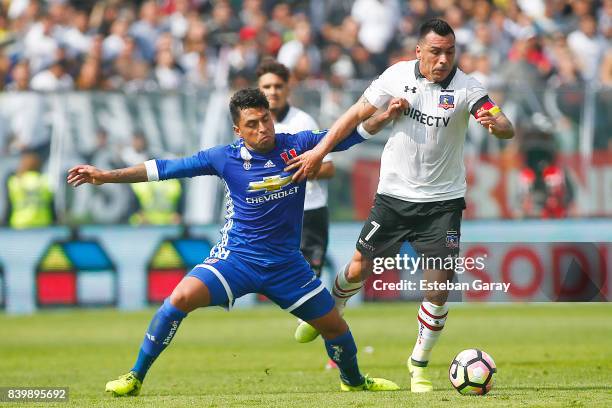 Esteban Paredes of Colo-Colo struggles for the ball with Gonzalo Jara of U de Chile during a match between Colo-Colo and Universidad de Chile as part...
