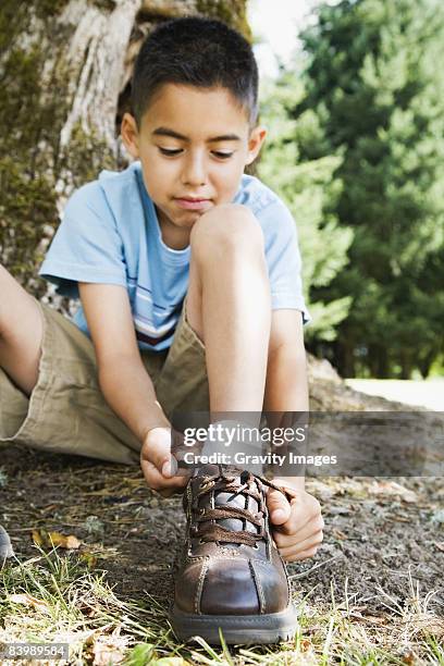 little boy tying his shoe - boy tying shoes stock-fotos und bilder