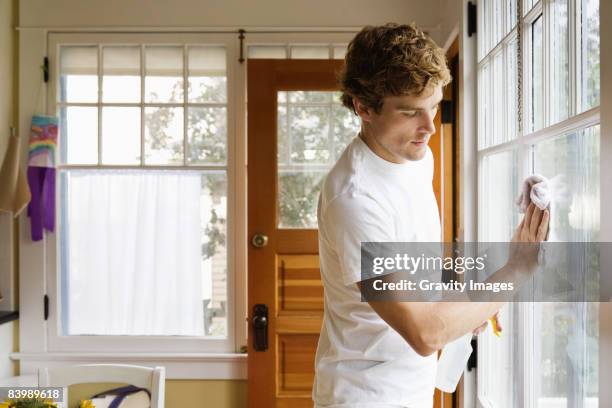 man washing house windows - cleaning stockfoto's en -beelden