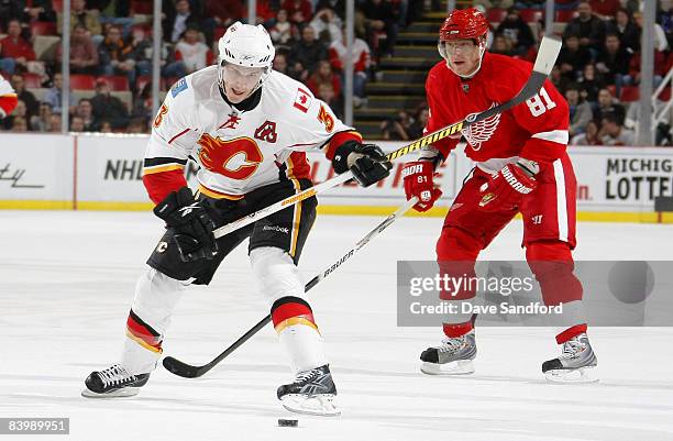 Marian Hossa of the Detroit Red Wings backchecks as Dion Phaneuf of the Calgary Flames takes a shot during their NHL game at Joe Louis Arena December...