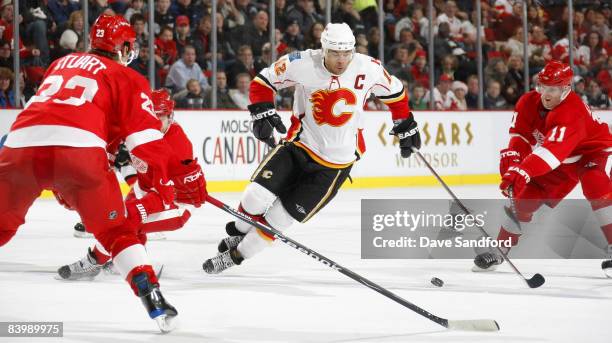 Brad Stuart and Dan Cleary both of the Detroit Red Wings defend against Jarome Iginla of the Calgary Flames during their NHL game at Joe Louis Arena...