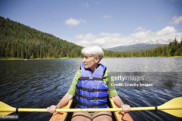 retired woman kayaking  - jaqueta salva vidas - fotografias e filmes do acervo