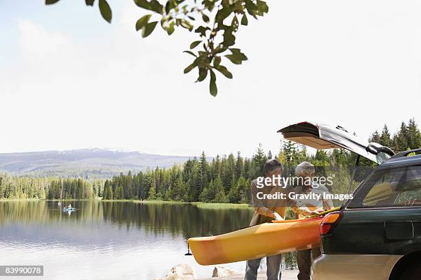 retired couple getting ready to kayak - mature adult couple stockfoto's en -beelden