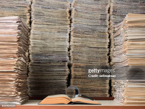 große menge von dokumenten, bücher und zeitungen in bibliothek - newspaper stack stock-fotos und bilder