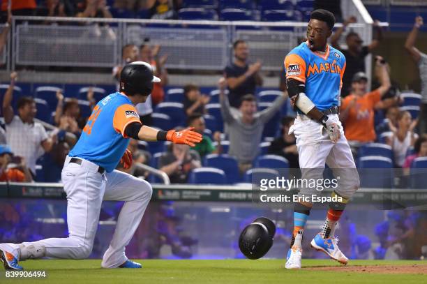 Dee Gordon of the Miami Marlins celebrates with Christian Yelich after scoring a run in the third inning against the San Diego Padres at Marlins Park...