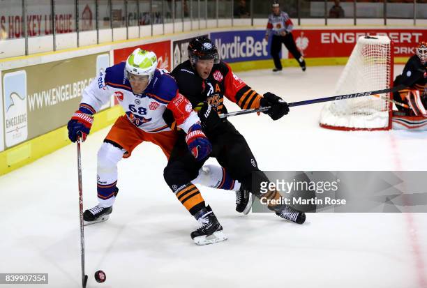 Mark Voakes of Wolfsburg and Joona Luoto of Tampere battle for the puck during the Champions Hockey League match between Grizzlys Wolfsburg and...