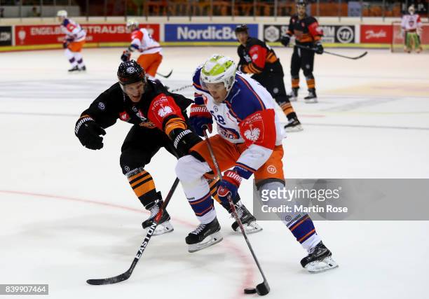Torsten Ankert of Wolfsburg and Joona Luoto of Tampere battle for the puck during the Champions Hockey League match between Grizzlys Wolfsburg and...