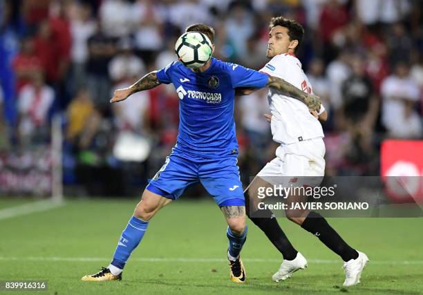 Sevilla's midfielder Jesus Navas vies with Getafe's Portuguese defender Gabriel Antunes during the Spanish league football match Getafe CF vs Sevilla...