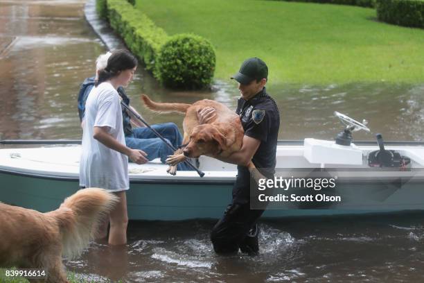Volunteers and officers from the neiborhood security patrol help to rescue residents and their dogs in the upscale River Oaks neighborhood after it...