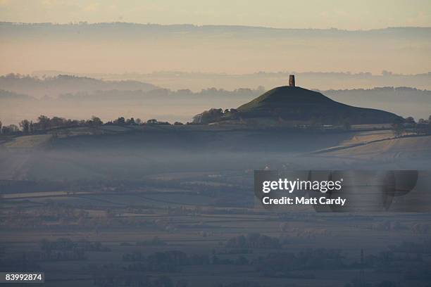 The winter sun rises over mist and frost surrounding the Glastonbury Tor viewed from the Mendip Hills on December 11, 2008 in Somerset, England....