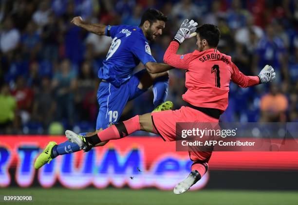 Sevilla's goalkeeper Sergio Rico Gonzalez vies with Getafe's forward Jorge Molina during the Spanish league football match Getafe CF vs Sevilla FC at...