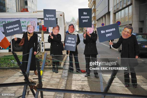 Roup of five protesters wearing masks featuring Germany's Chancellor Angela Merkel, France's President Nicolas Sarkozy, Britain's Prime Minister...