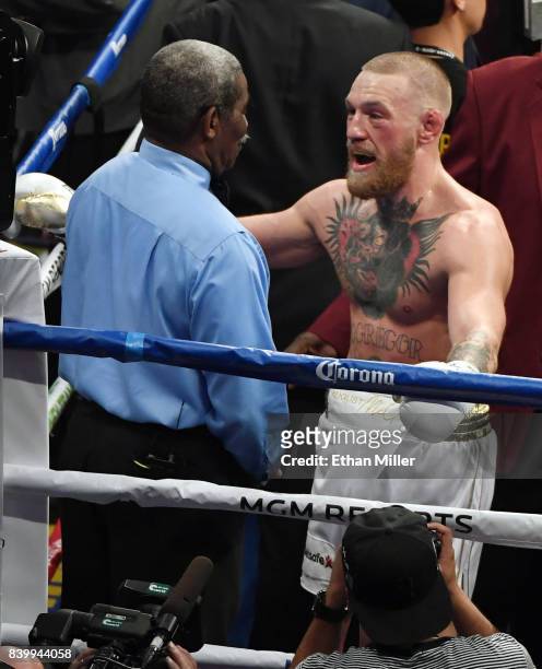 Conor McGregor talks with referee Robert Byrd after he stopped McGregor's super welterweight boxing match against Floyd Mayweather Jr. Giving him a...