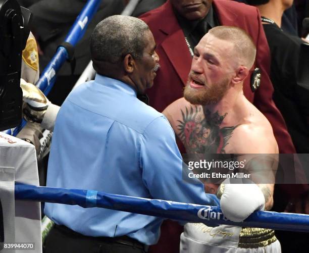 Conor McGregor talks with referee Robert Byrd after he stopped McGregor's super welterweight boxing match against Floyd Mayweather Jr. Giving him a...