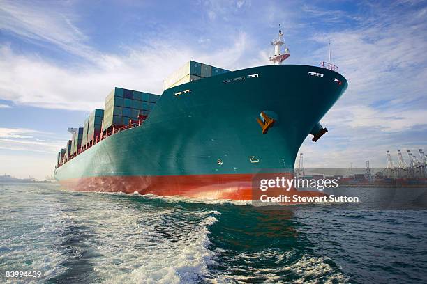 bow view of loaded cargo ship sailing out of port. - ship stockfoto's en -beelden