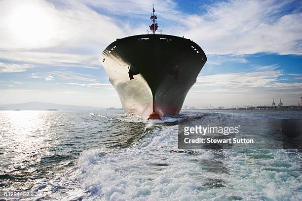 bow view of cargo ship sailing out of port. - ships bow stock pictures, royalty-free photos & images