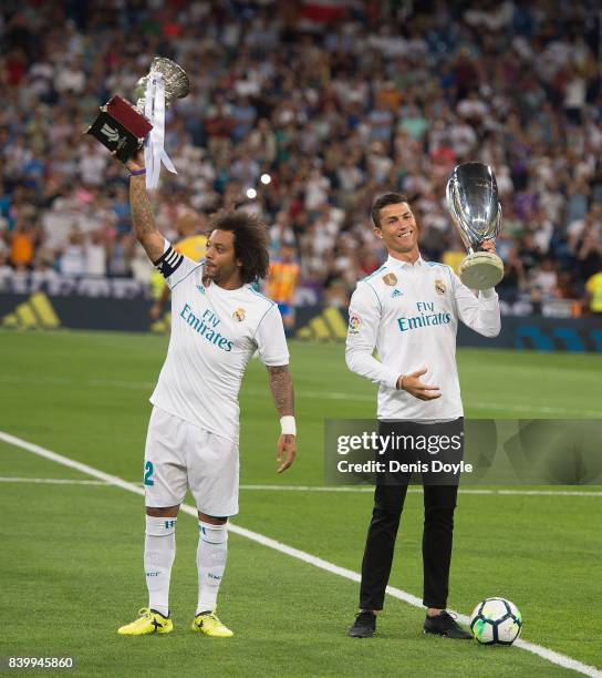 Cristiano Ronaldo and Marcelo of Real Madrid CF hold up the UEFA Super Cup and LaLiga title for 2016/2017 before the La Liga match between Real...