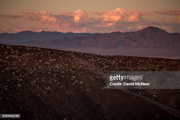 The edge of Amboy Crater and distant mountains are seen just before sunrise at Mojave Trails National Monument on August 27, 2017 near Essex,...