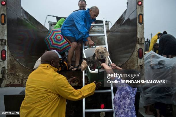 Evacuation residence from the Meyerland area are loaded onto a truck on an I-610 overpass during the aftermath of Hurricane Harvey August 27, 2017 in...