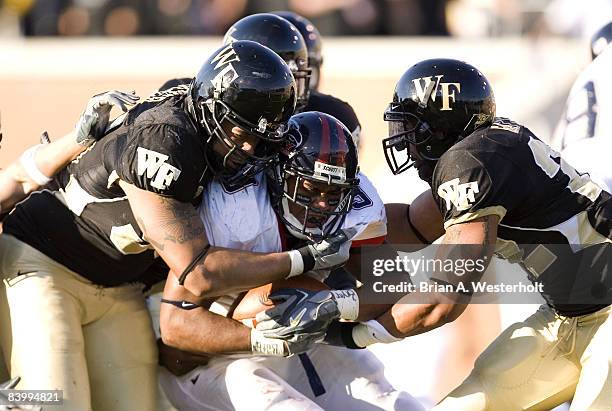 Liberty running back Rashad Jennings is stuffed at the line of scrimmage by Wake Forest linebacker Jyles Tucker and defensive back Josh Gattis during...