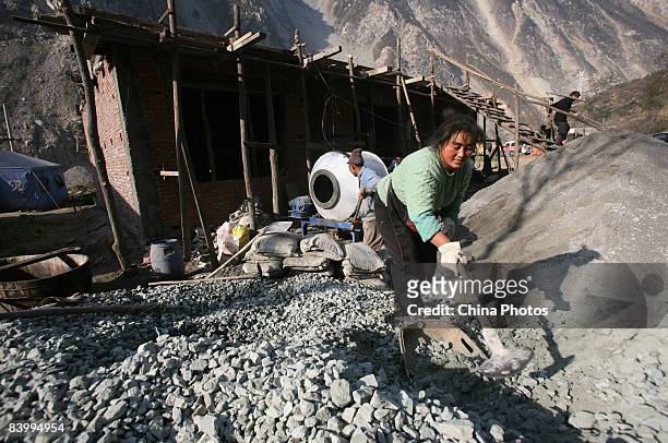 Qiang ethnic minority woman Su Mei, whose son died in the May 12 Sichuan Earthquake, helps her sister to rebuild a house at the Yingxiu Township on...