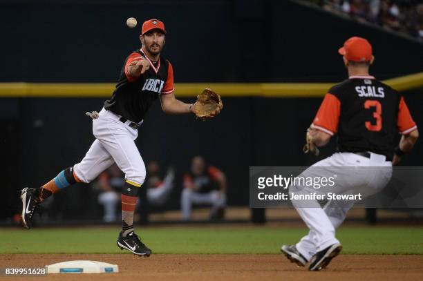 Adam Rosales of the Arizona Diamondbacks tosses the ball to Daniel Descalso to turn the double play against the San Francisco Giants in the fourth...