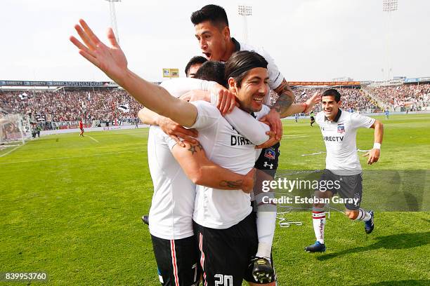 Jaime Valdes of Colo-Colo celebrates with teammates after scoring the second goal of his team during a match between Colo-Colo and U de Chile as part...