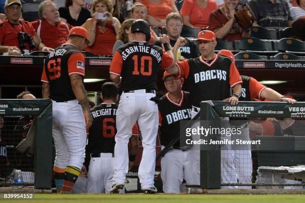Chris Herrmann of the Arizona Diamondbacks wearing a nickname-bearing jersey is congratulated by manager Torey Lovullo after scoring on a wild pitch...