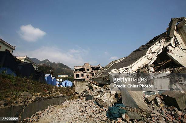 Prefabricated houses sit opposite debris left by the May 12 Sichuan Earthquake on December 10, 2008 in Wenchuan County of Sichuan Province, China....