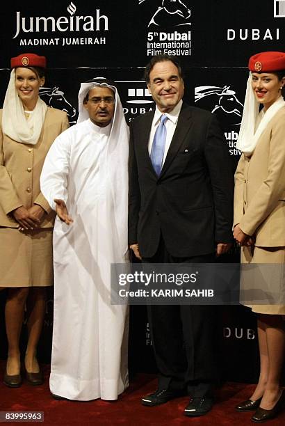 Director, producer and screenwriter Oliver Stone poses on the red carpet with Dubai International Film Festival chairman Abdulhamid Juma during the...