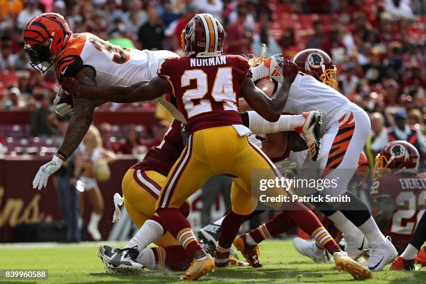 Running back Jeremy Hill of the Cincinnati Bengals leaps into the end zone for a touch down in front of cornerback Josh Norman of the Washington...