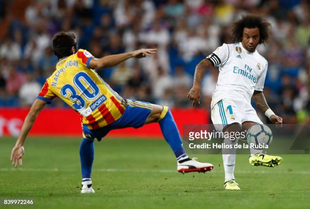 Marcelo of Real Madrid and Nacho Vidal of Valencia cf compete for the ball during the La Liga match between Real Madrid and Valencia CF at Estadio...