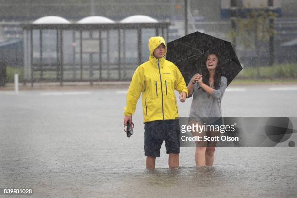 Students make their way across a flooded parking lot on the campus of Rice University afer it was inundated with water from Hurricane Harvey on...