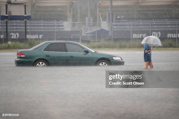 Mari Zertuche walks through a flooded parking lot on the campus of Rice University afer it was inundated with water from Hurricane Harvey on August...