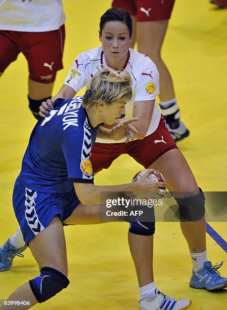 Ukrainian Maryna Vergeliuk is pushed by Danish Kamilla Kristensen during the 8th Women's Handball European Championships match on December 11, 2008...