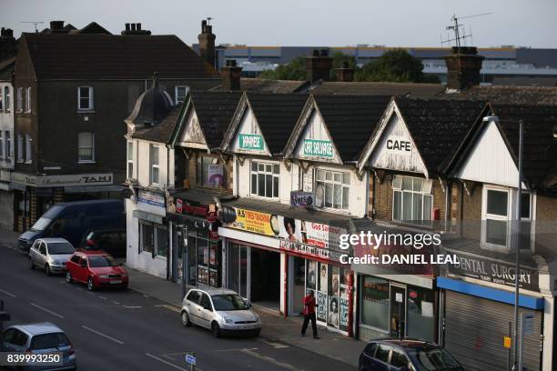 Resident walks past shops near the station in the dock town of Tilbury in Essex, east of London on August 26, 2017. - In the run down dock town of...