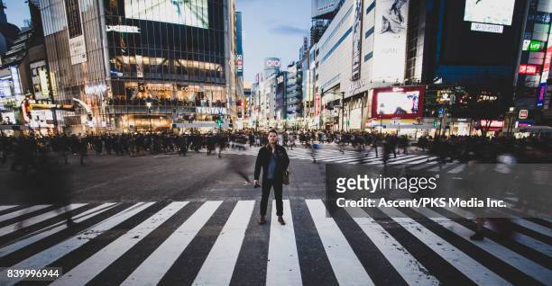 man poses for long exposure shibuya crossing - pose longue photos et images de collection
