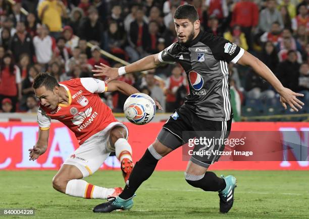 Anderson Plata of Santa Fe struggles for the ball with Matias De Los Santos of Millonarios during a match between Independiente Santa Fe and...
