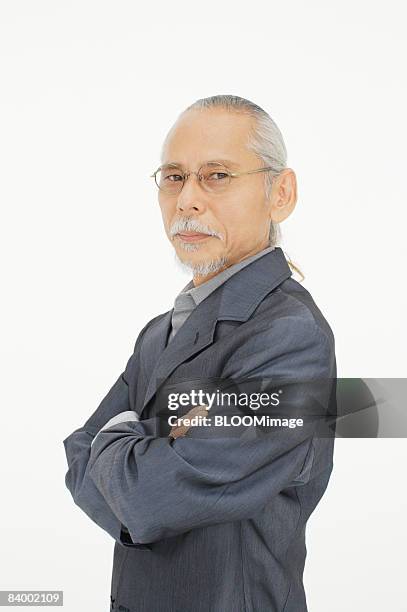 portrait of senior man with arms folded, close-up, studio shot - portrait close up loosely stock pictures, royalty-free photos & images