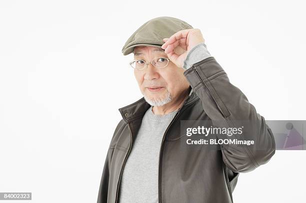 portrait of senior man wearing hat and glasses, close-up, studio shot - portrait close up loosely stock pictures, royalty-free photos & images