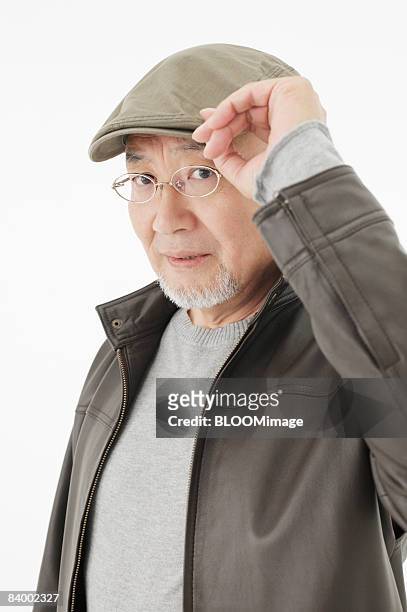portrait of senior man wearing hat and glasses, close-up, studio shot - portrait close up loosely stock pictures, royalty-free photos & images