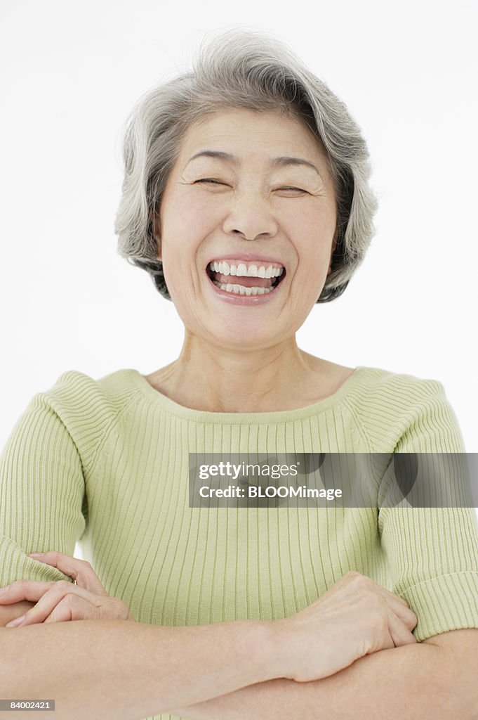 Portrait of senior woman with arms folded, close-up, studio shot