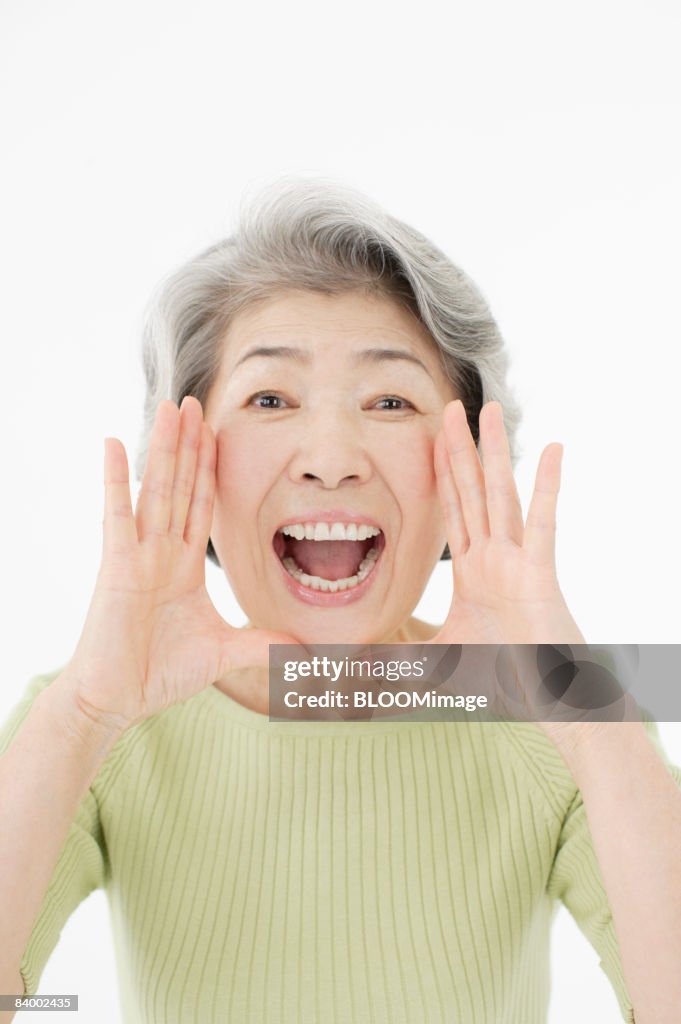 Portrait of senior woman shouting, close-up, studio shot